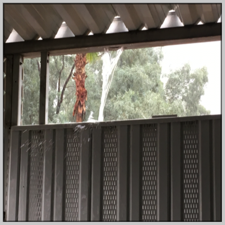 Rain pouring over the gutters during the storm.